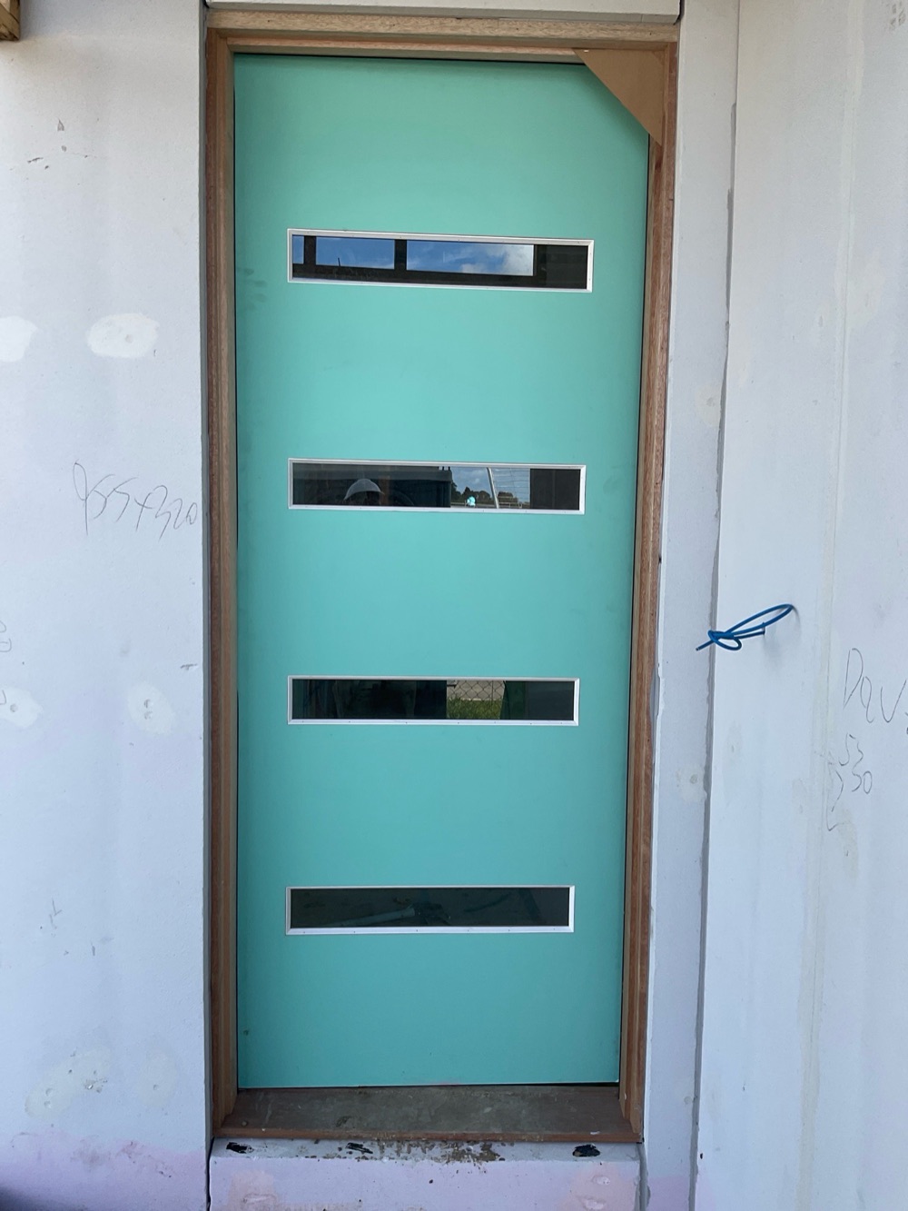 No flashing under the external doors, so water can track into the wall, found during a lock-up inspection in Clyde