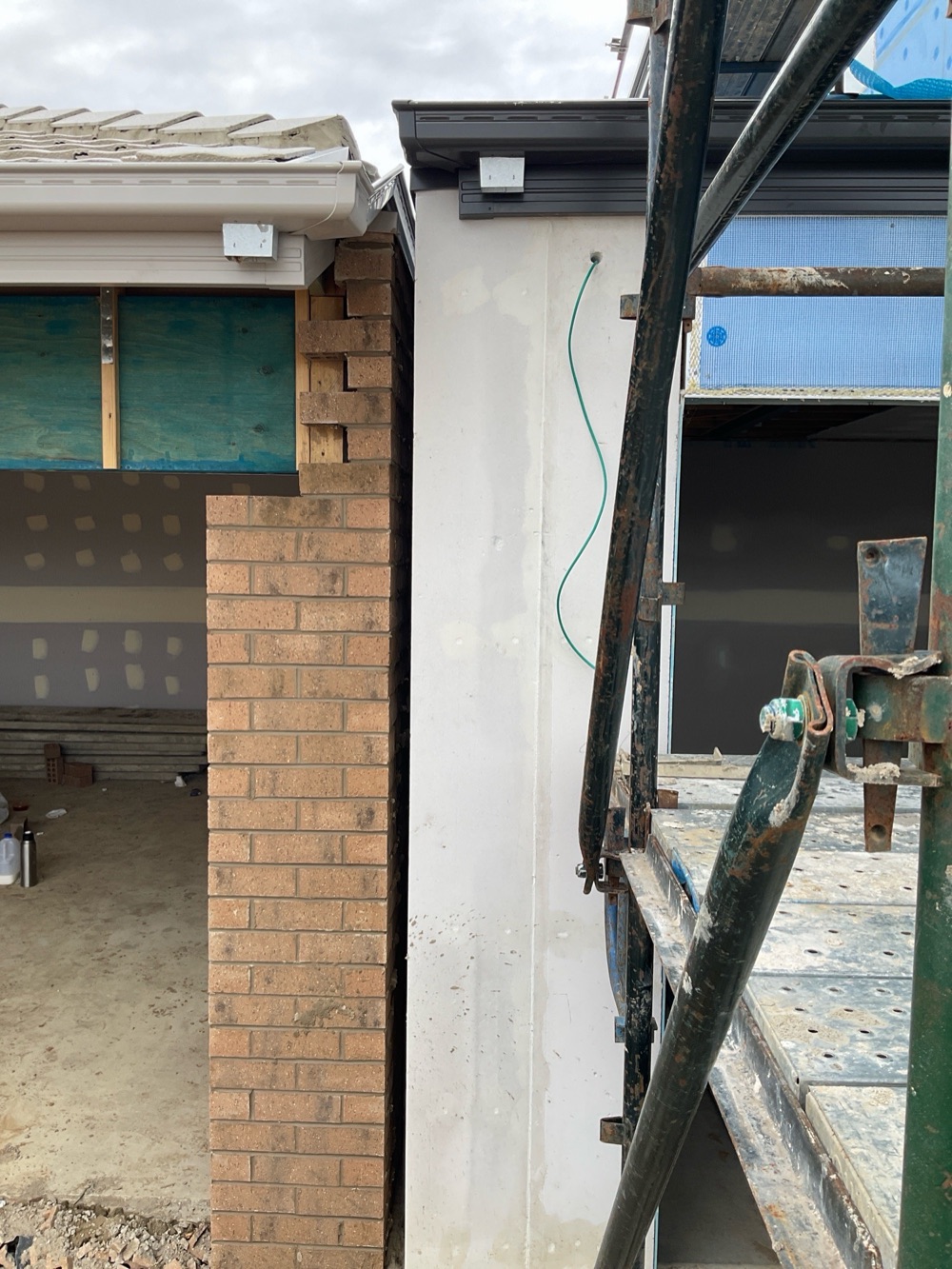 Ground floor downpipes not installed, leaving roof water discharging beside the slab, found during a fixing and waterproofing inspection in Clyde
