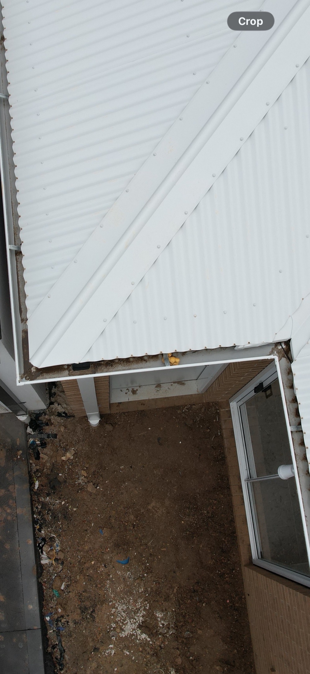 Debris left in the gutters, blocking roof water from reaching the downpipes, found during a pre-handover inspection in Clyde